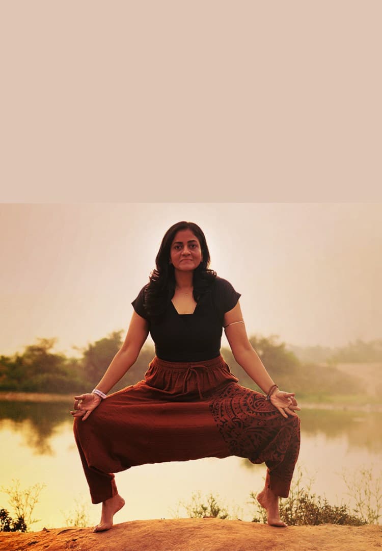 Shuchita in a goddess pose by the lake at sunset